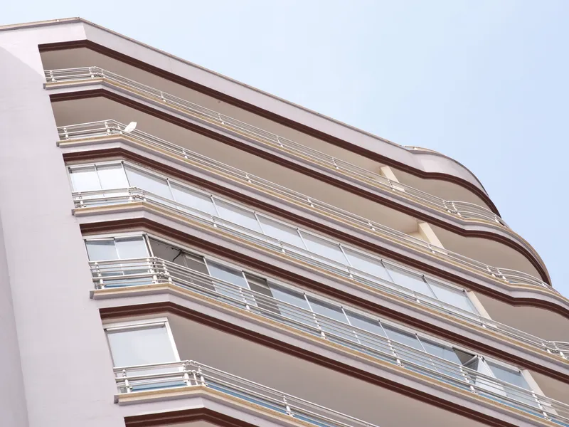 Diagonal view of a modern building facade with stacked balconies, Texas real estate