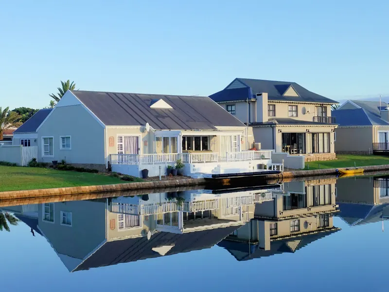 Waterfront home with private dock reflected in a calm canal, Texas real estate
