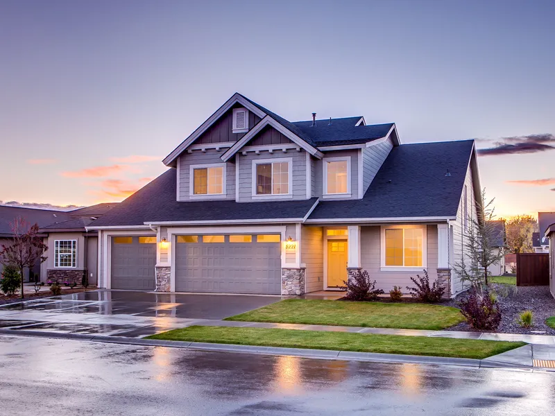Two-story family home with three-car garage lit at sunset, Texas real estate